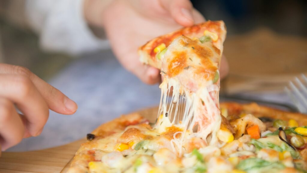 a man taking a slice of pizza, best pizza in Naples Italy