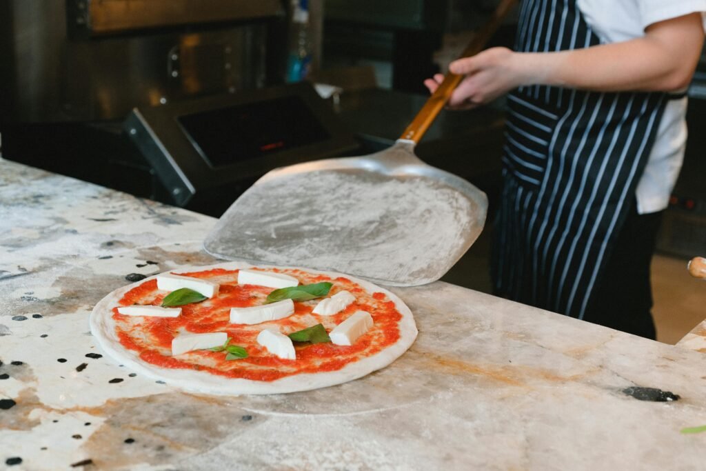 Person Holding a Peel Beside a Pizza, Antica Pizzeria da Michele Naples