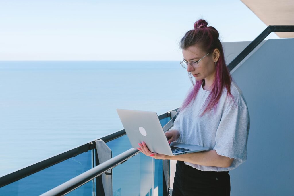 Young Woman Working Remotely by the Sea