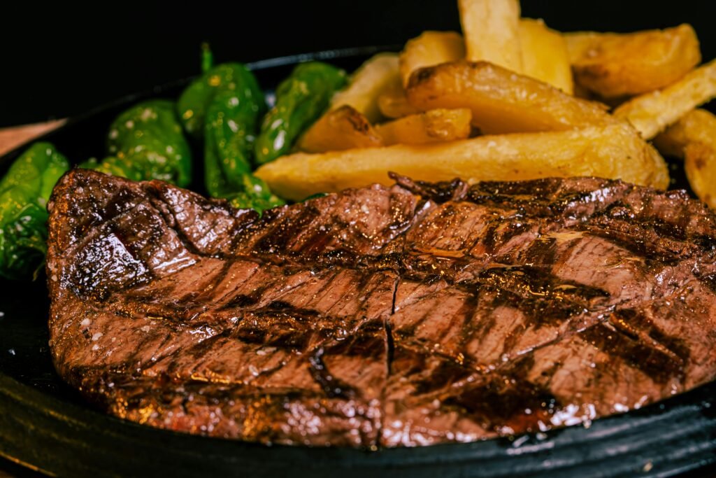 A steak and fries on a plate with a fork